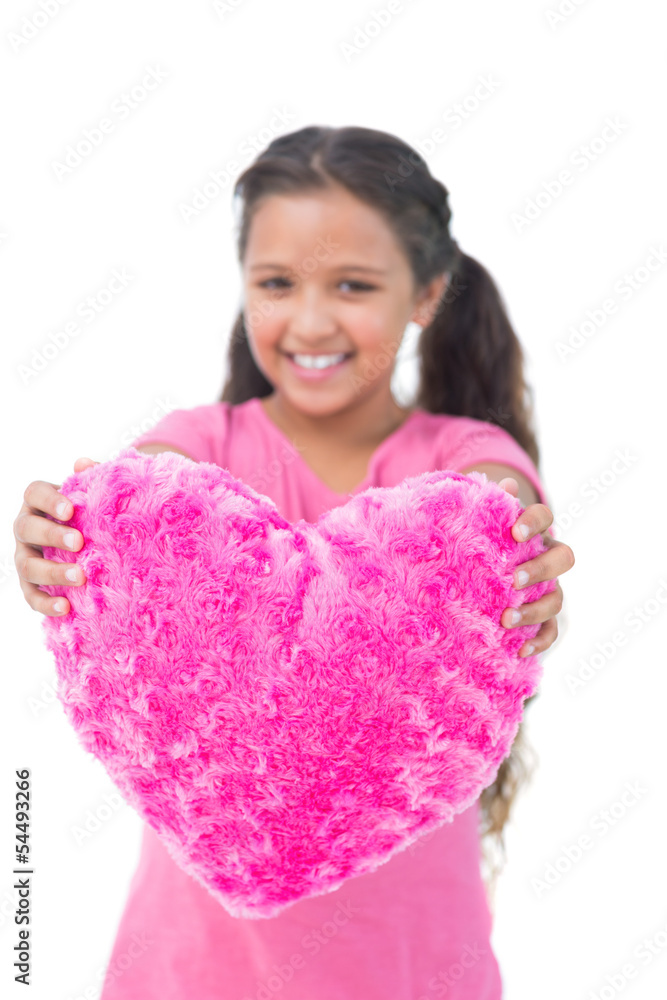 Little girl showing cushion in the shape of a heart Little girl showing cushion in the shape of a heart