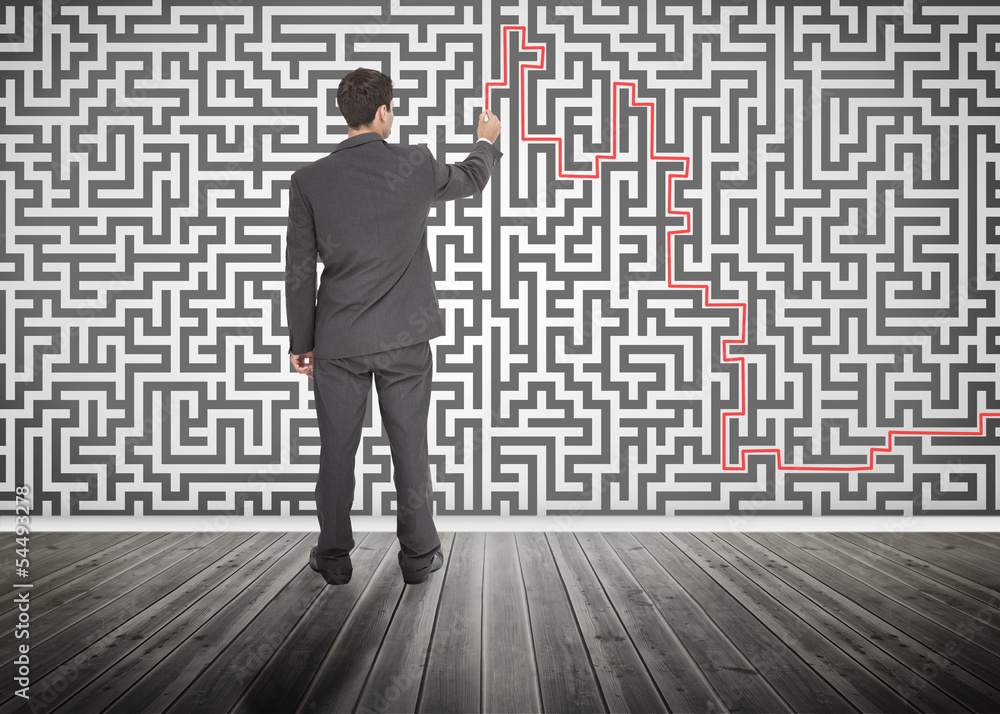 Businessman tracing a red line on a maze Businessman tracing a red line on a maze