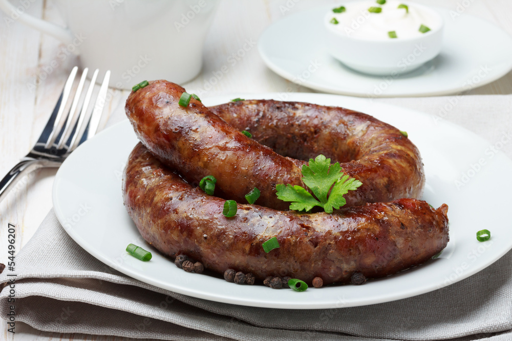 Traditional homemade coiled sausage on wooden table Traditional homemade coiled sausage on wooden table