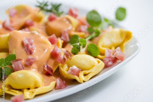 fresh tortellini in light sauce with ham photo