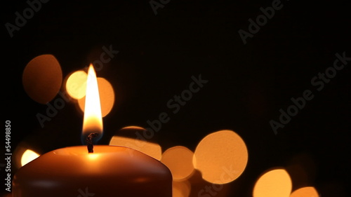 Igniting of candle on black background with copy space