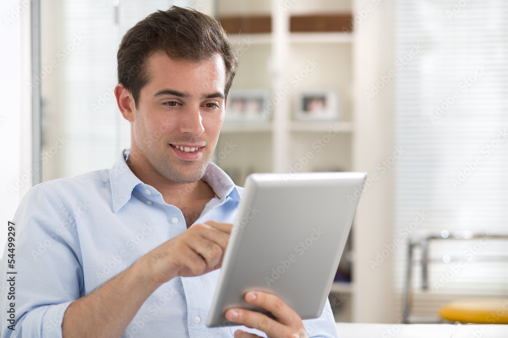 Man using tablet pc on couch at home Man using tablet pc on couch at home