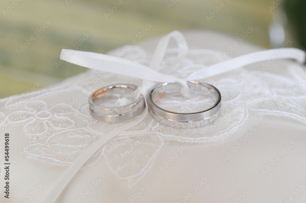 Closeup of silver wedding rings on a pillow Closeup of silver wedding rings on a pillow
