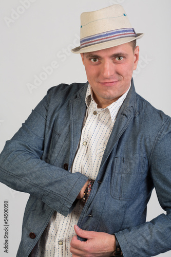 The man in hat puts his hand in his jacket pocket photo