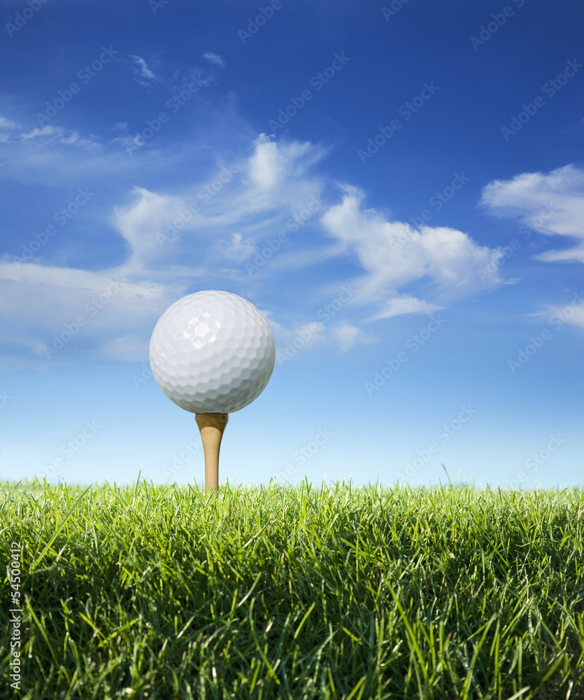 Golf ball on tee in grass viewed close up Golf ball on tee in grass viewed close up