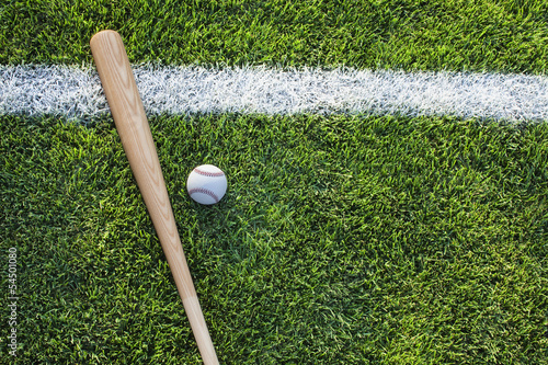 Baseball bat and ball on grass field viewed from above
