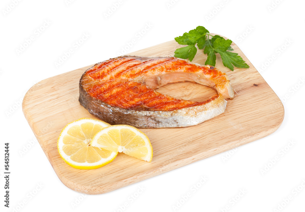 Grilled salmon with lemon and herbs on cutting board Grilled salmon with lemon and herbs on cutting board