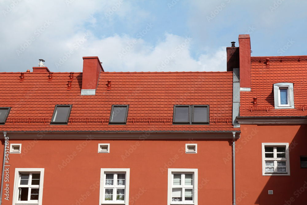 Fototapeta premium red building with tile roof against blue sky