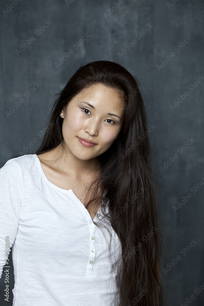 Asian young woman standing by wall Asian young woman standing by wall