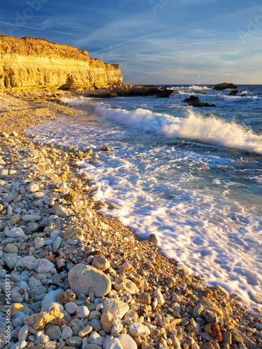 Waves and pebbles on the seashore. Beautiful summer composition