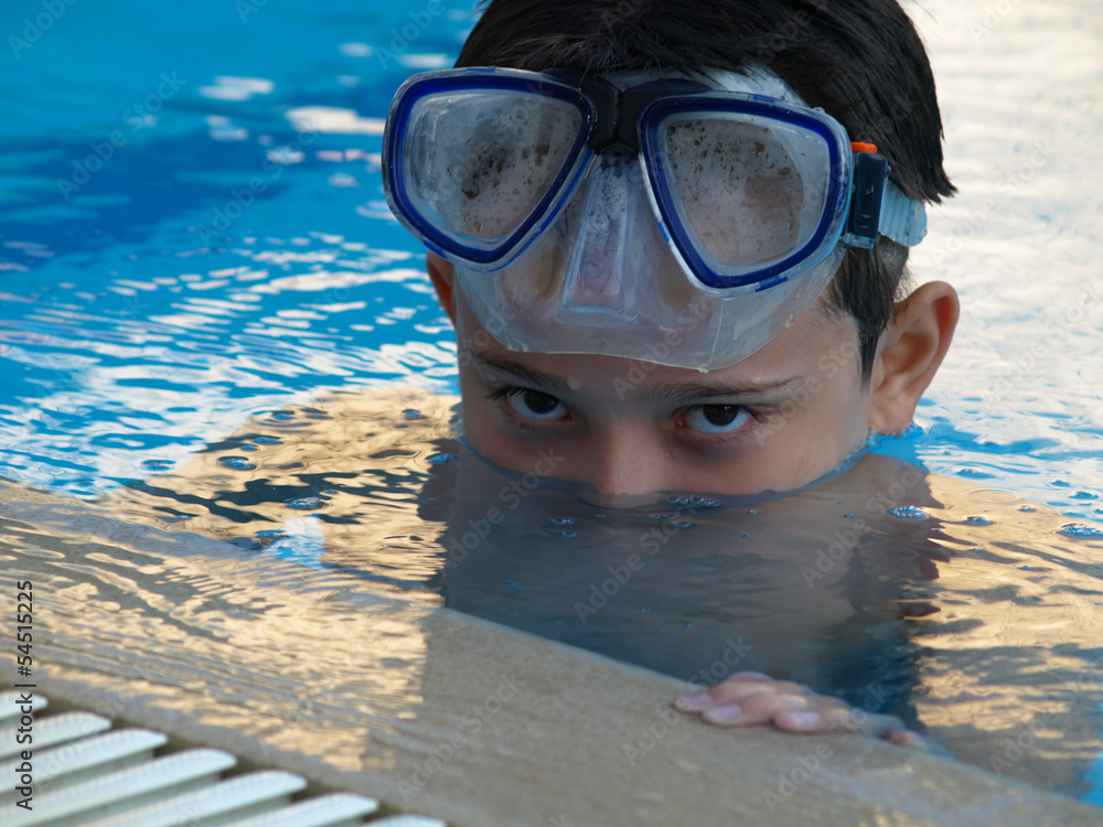 Naklejka premium Cute boy swimming and playing in water