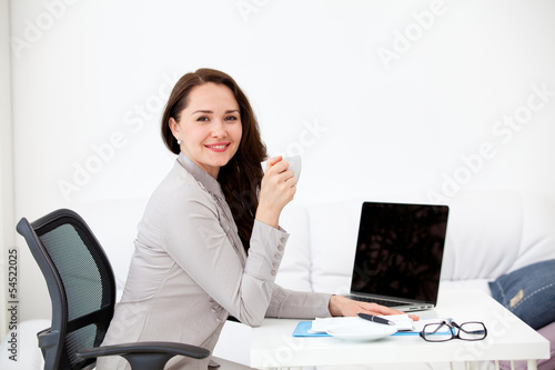 woman drinking coffee at desk