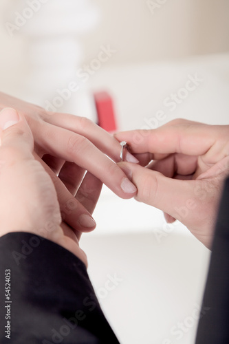 Man slipping an engagement ring onto her finger