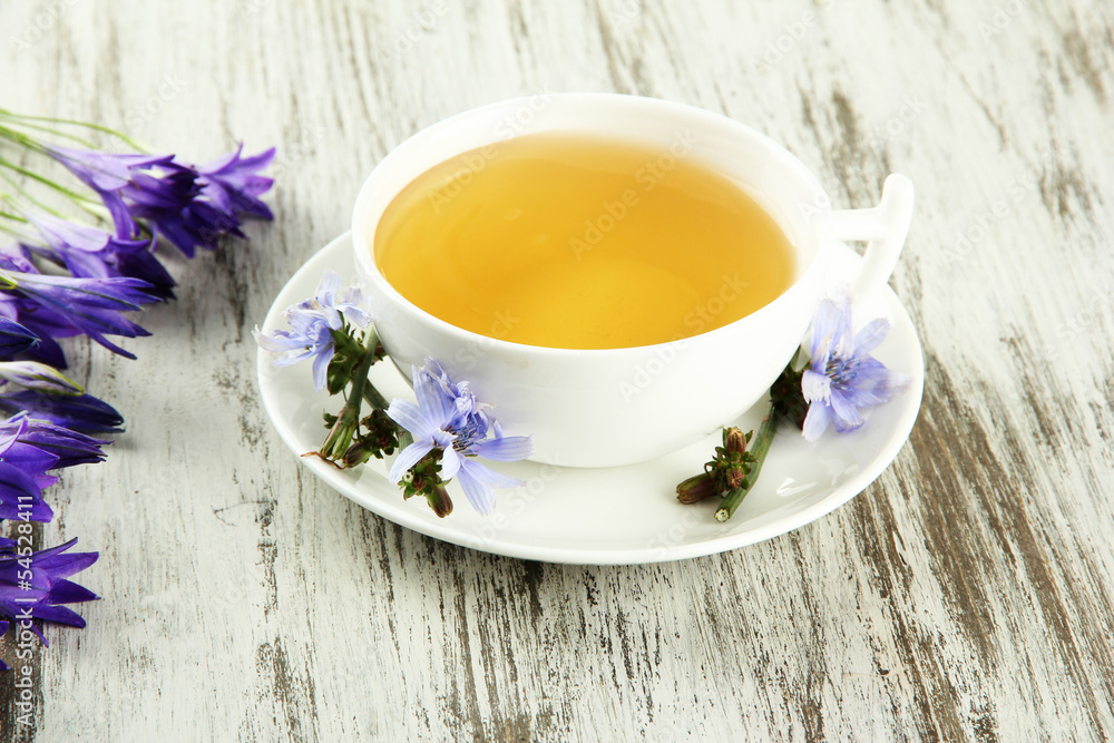 Cup of tea with chicory, on wooden background Cup of tea with chicory, on wooden background