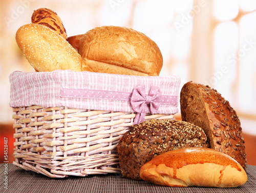 Baked bread in wicker basket on window background