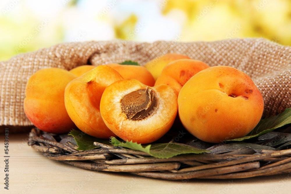 Apricots on wicker coasters on wooden table on nature