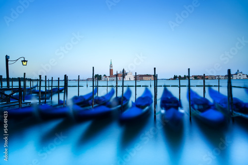 Venice, gondolas on sunset and church on background. Italy