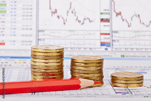 Downtrend coins stacks, red pencil, financial chart as backgroun