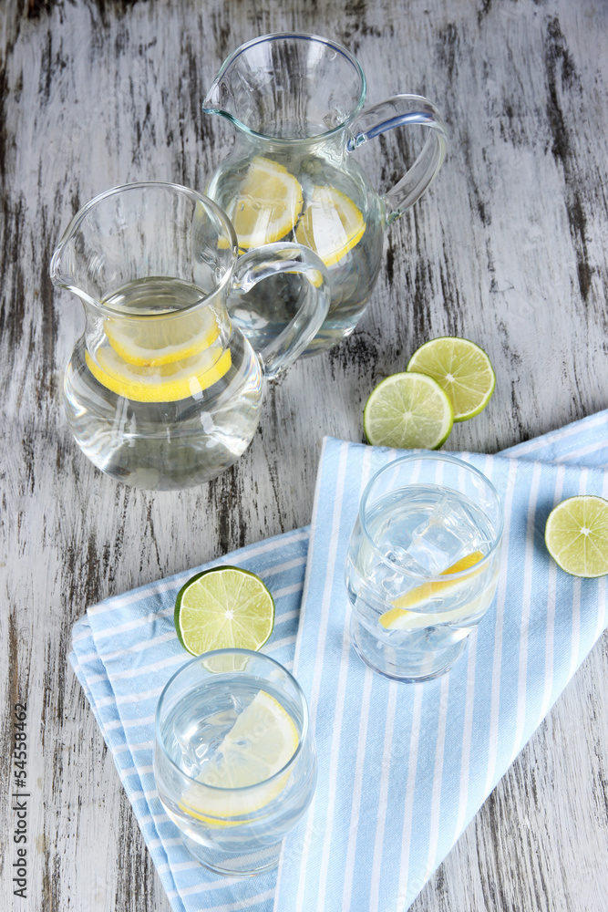 Glass pitchers of water and glasses on wooden table close-up Glass pitchers of water and glasses on wooden table close-up