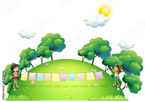 Two girls with hanging clothes at the hilltop