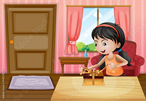 A girl opening her gift inside the house
