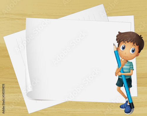 A kid holding a pencil beside the empty papers