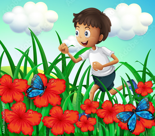 A boy running at the garden with flowers and butterflies