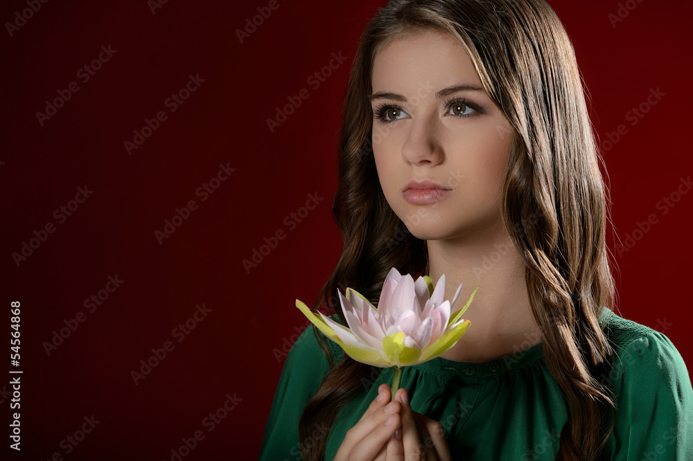 Thoughtful teenage girl. Pretty teenage girl holding a flower an