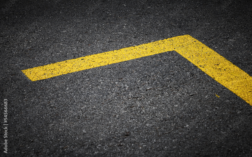 Road marking with yellow lines on dark asphalt