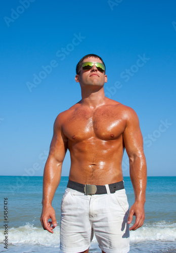 Muscular brutal man on the beach