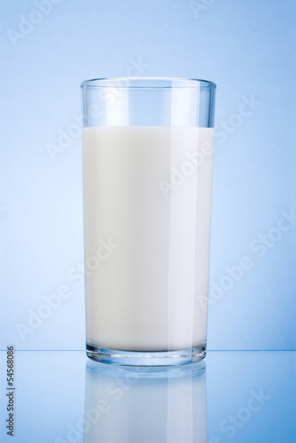 Glass of fresh milk isolated on a blue background