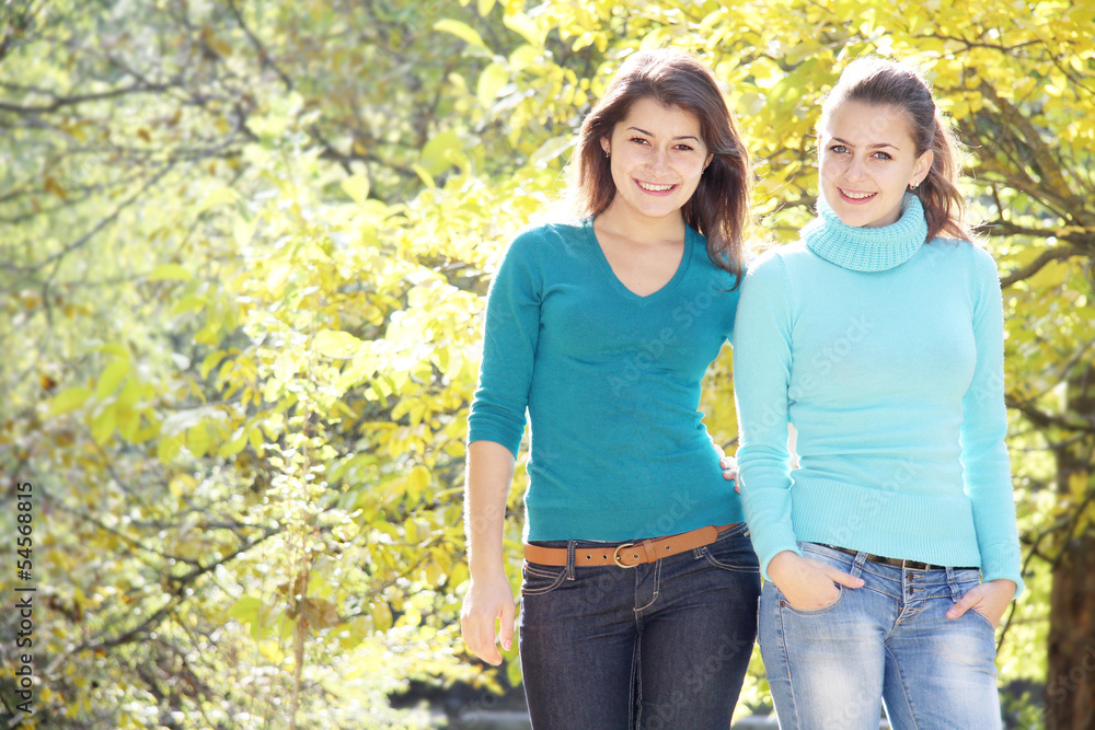 two young happy girls in autumn park outdoor portrait