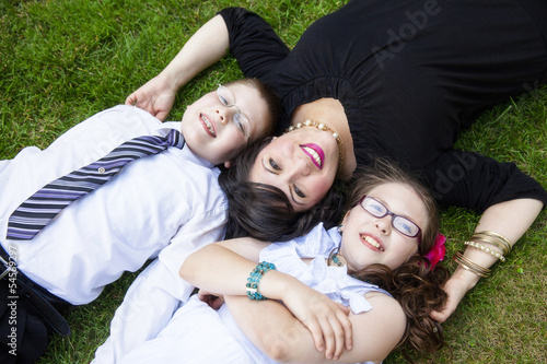 Mother with son and daughter laying in grass