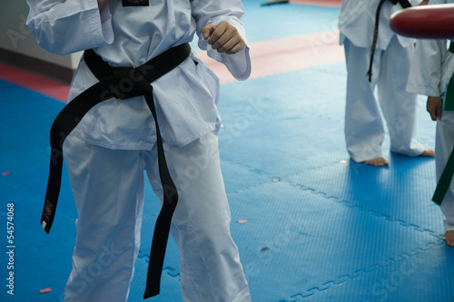 Taekwondo player practices kicking in gym