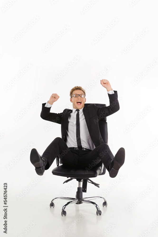 Businessman having fun. Cheerful young businessman sitting on th Businessman having fun. Cheerful young businessman sitting on th