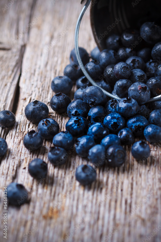 Some Blueberries in a small Bucket on wooden background Some Blueberries in a small Bucket on wooden background