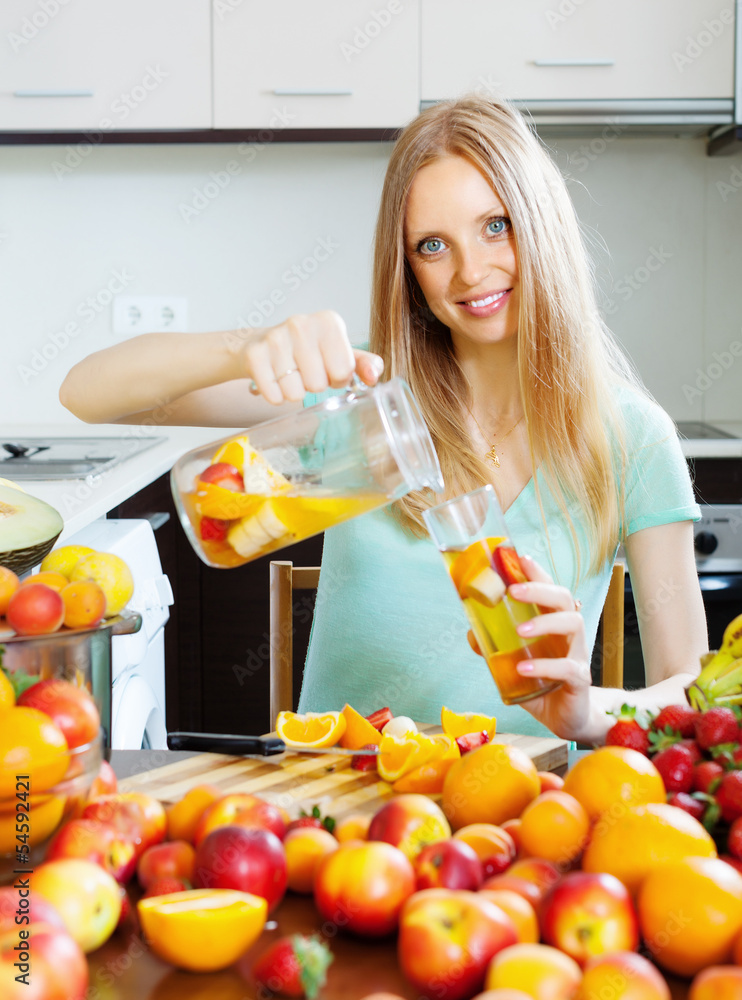 cheerful woman pouring beverages with fruits