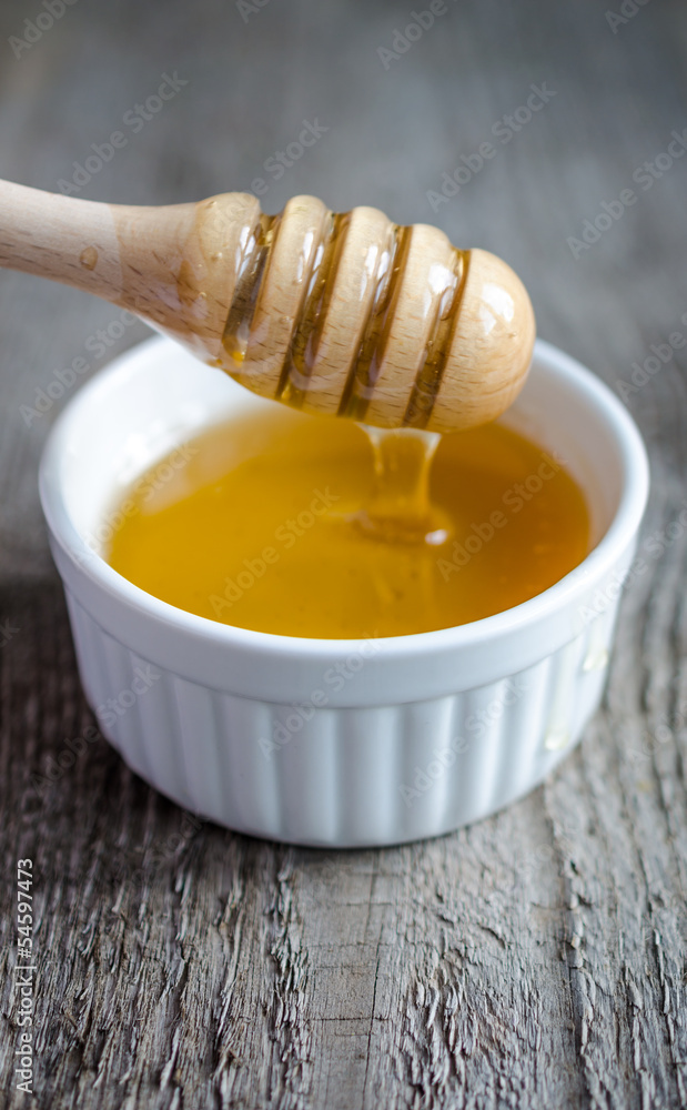 Honey bowl with dipper and flowing honey Honey bowl with dipper and flowing honey