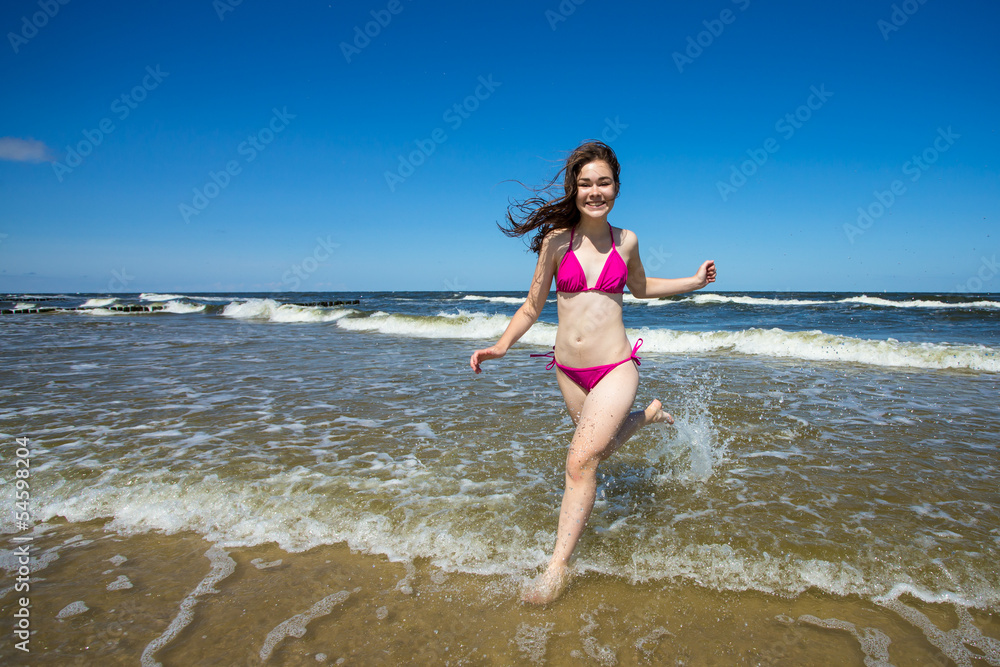 Teenage girl running, jumping on beach Teenage girl running, jumping on beach