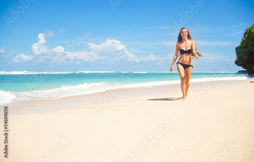 woman walking away on the idyllic beach © Mila Supinskaya 