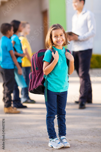 primary school student carrying backpack