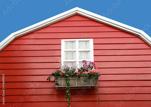 white window with flower on red barn