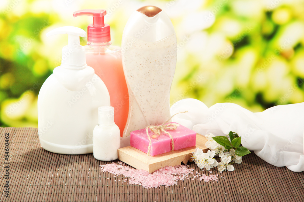 Cosmetics bottles and natural handmade soap on green background Cosmetics bottles and natural handmade soap on green background