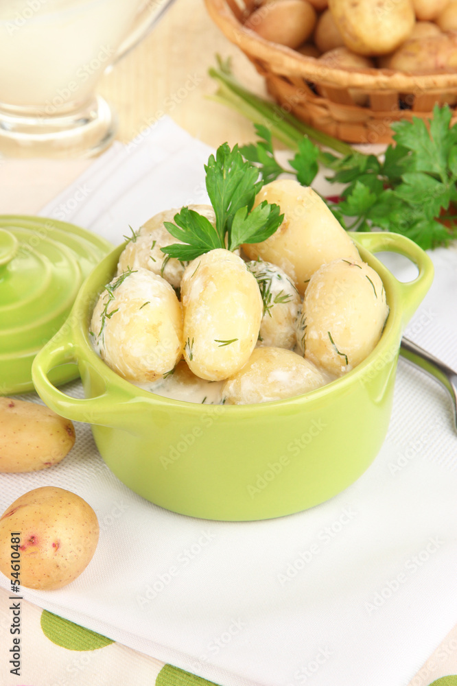 Tender young potatoes with sour cream and herbs in pan Tender young potatoes with sour cream and herbs in pan