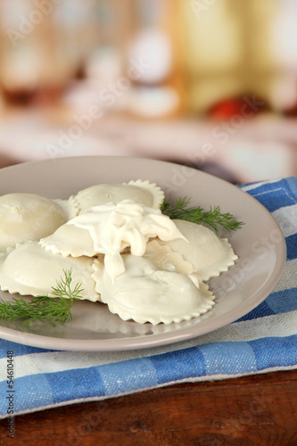 Tasty dumplings on plate, on wooden table