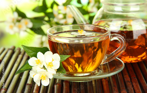 Cup of tea with jasmine, on bamboo mat, close-up