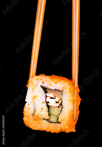 delicious sushi and chopsticks on black background
