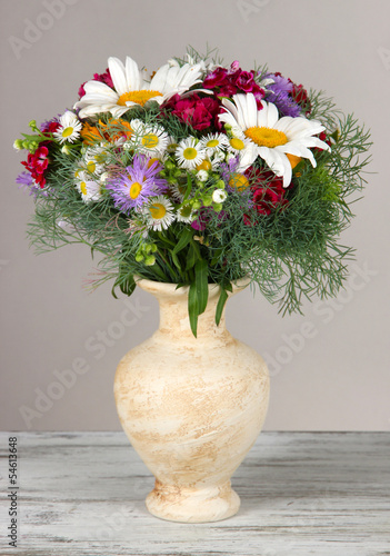 Wallpaper Mural Beautiful bright flowers in vase on table on gray background Torontodigital.ca