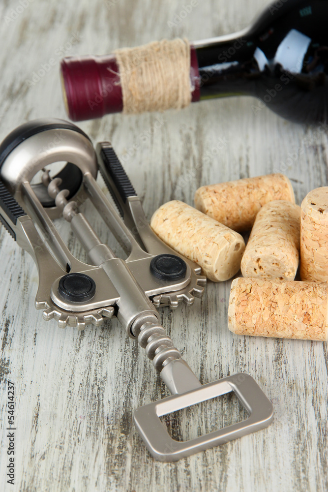 Corkscrew with wine corks and bottle of wine