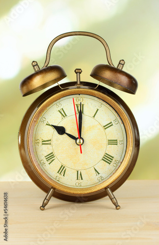 Alarm clock on table on light background